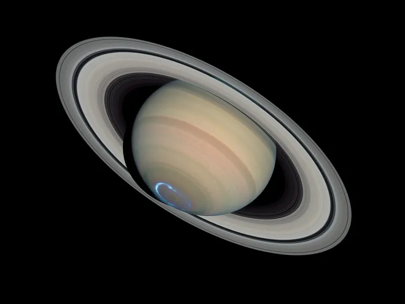 Saturn with a ring of blue light glowing over its south pole