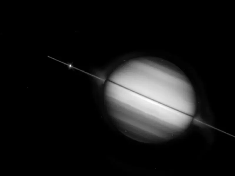Saturn with its rings seen exactly side-on, as a thin bright line across the planet