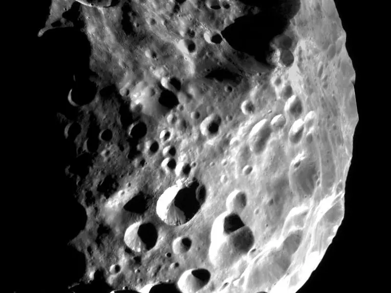 A dark, lumpy moon covered in craters