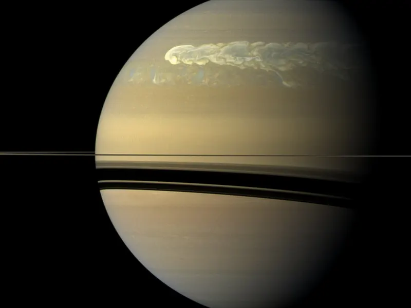 A white storm streaking across Saturn’s northern half