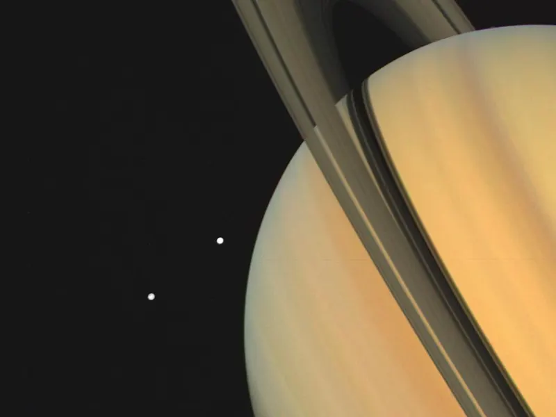 Saturn and its rings with two small moons, Tethys and Dione, beside it